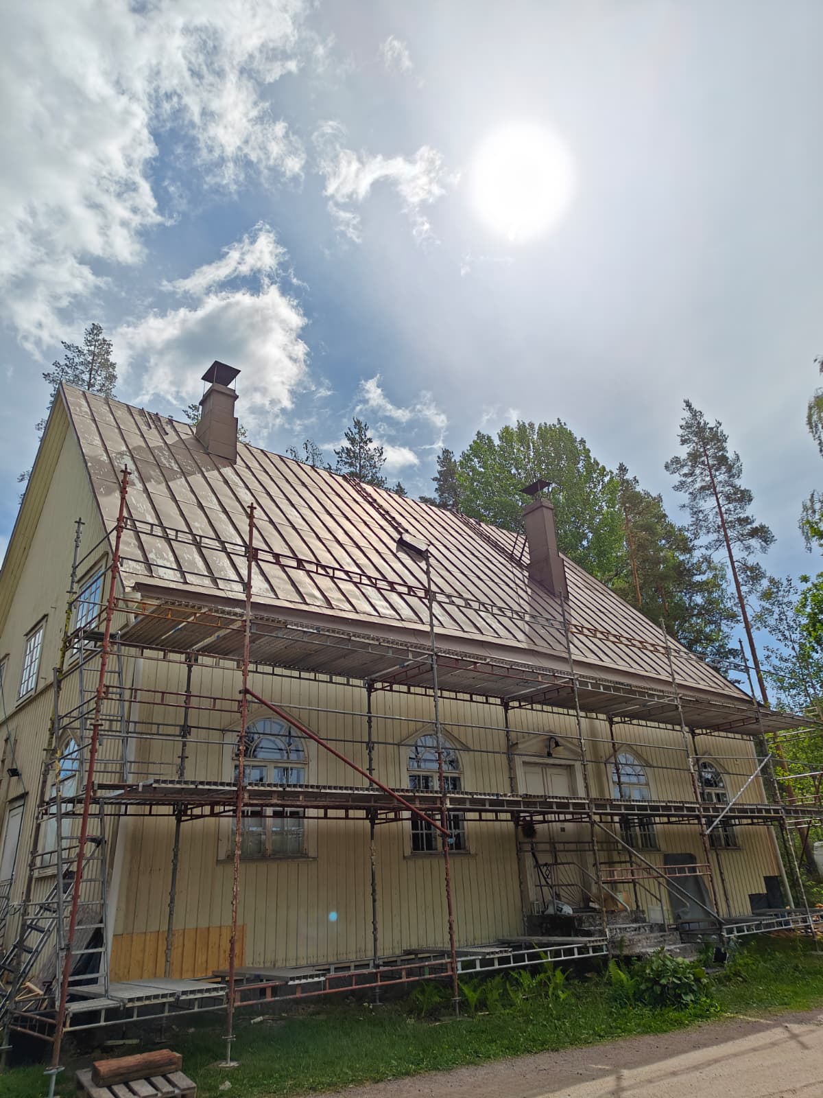 Vanha konesaumakatto ja rakennustelineet ennen etupihan töitä.